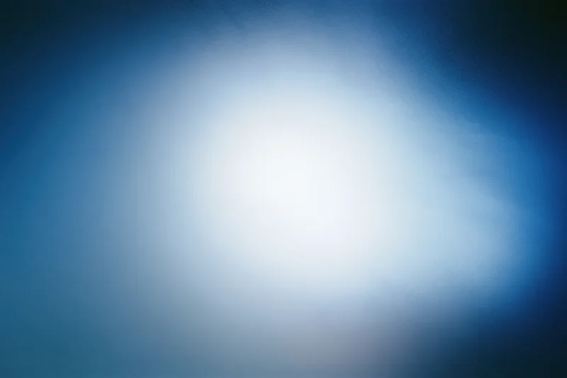 Diffused light passing through frosted glass surface creating soft blue-white gradient background