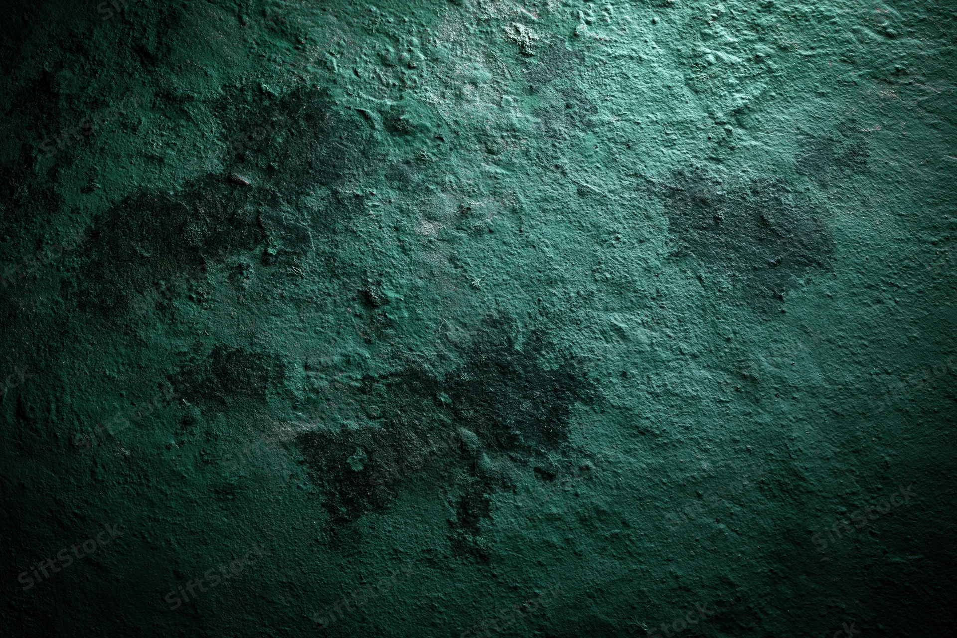 Textured green surface filling the frame with rough uneven pattern and dark shadows
