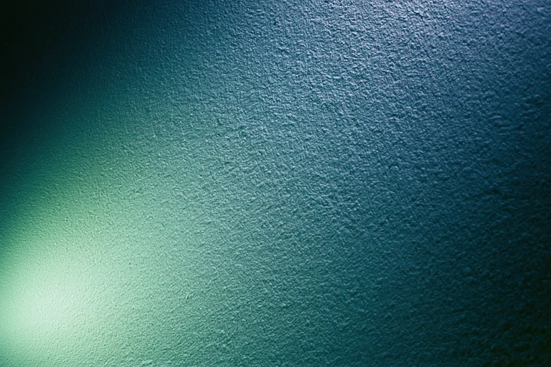 Abstract textured surface with soft glowing green light gradient