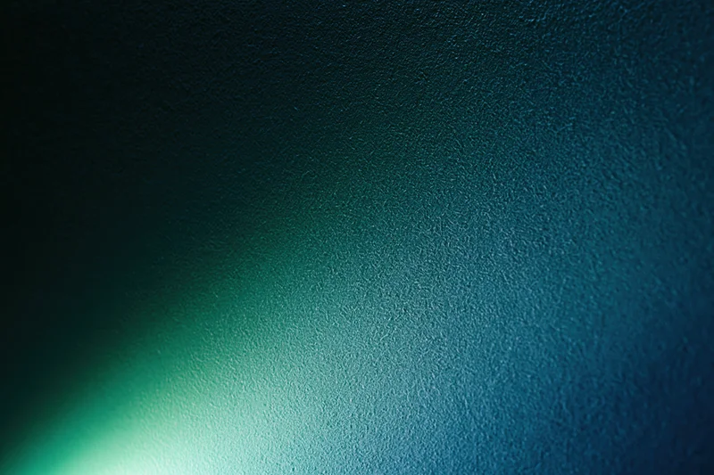Abstract textured surface with soft glowing green light gradient