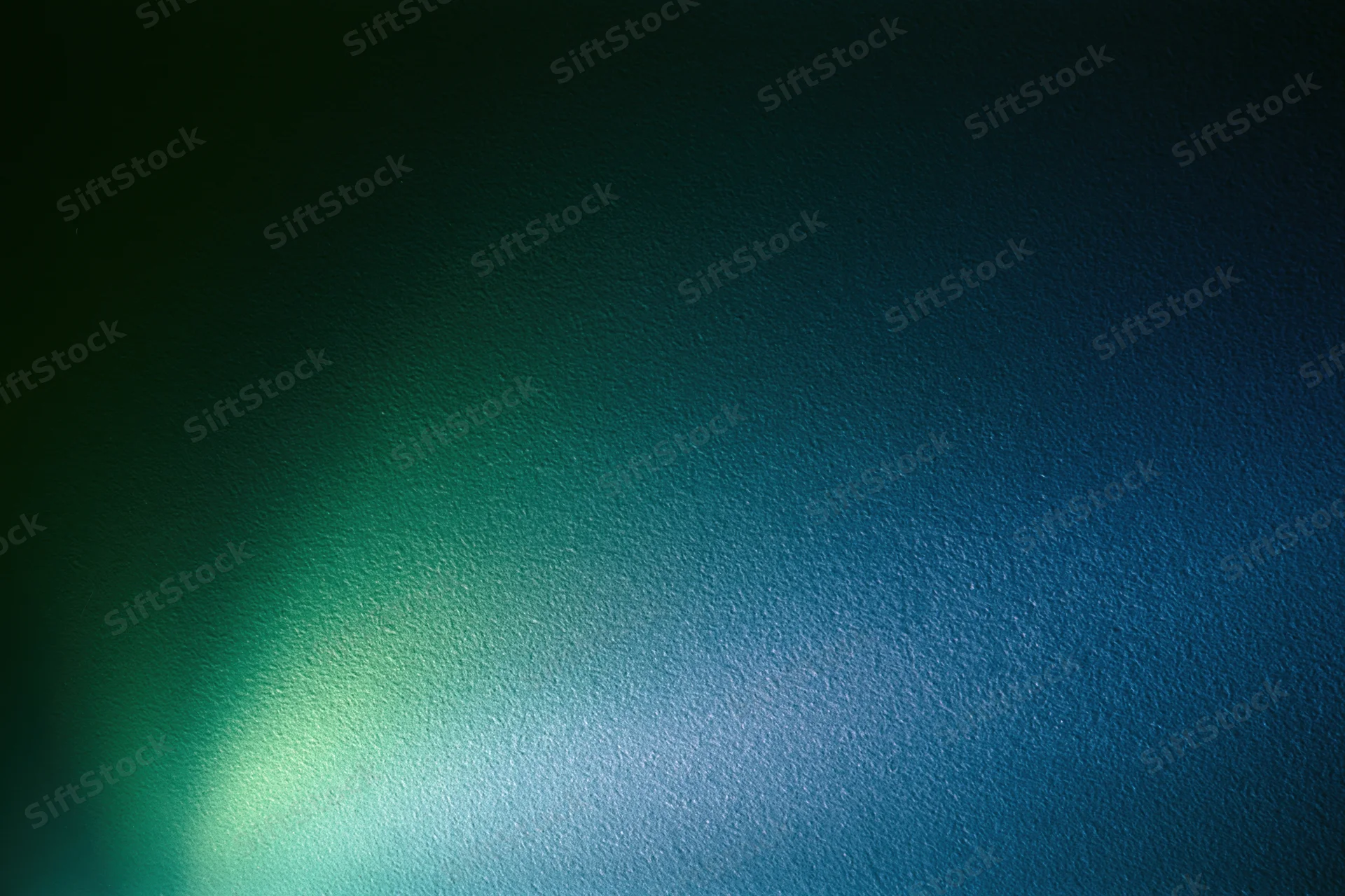 Abstract textured surface with soft glowing green and blue light gradient