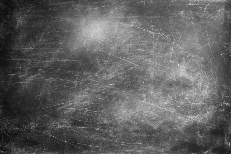 Aged black chalkboard surface covered in fine scratches and dust