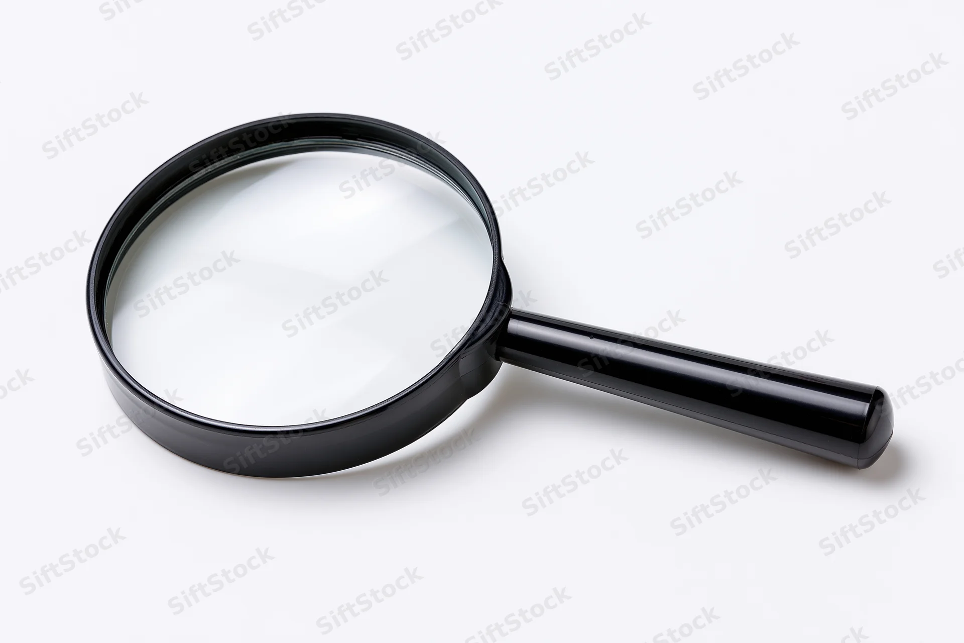 Black magnifying glass with glossy plastic handle resting on white surface