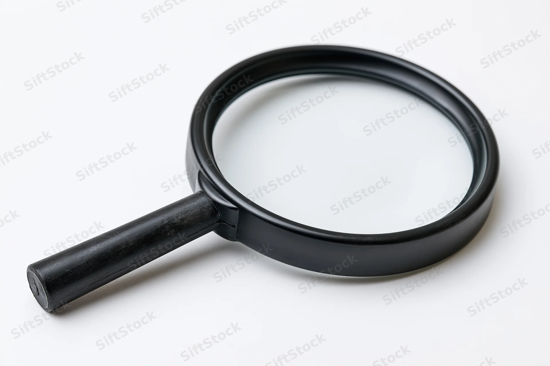 Black plastic magnifying glass with cylindrical handle resting on white surface