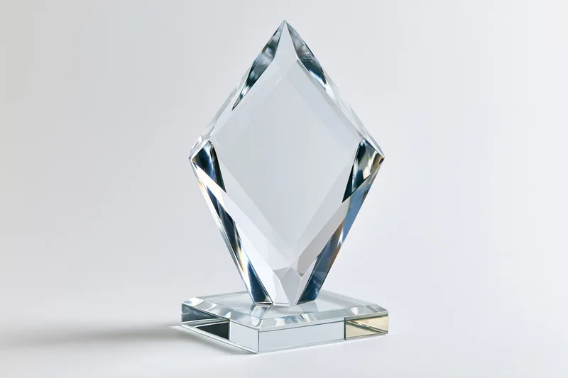 Blank crystal glass award trophy standing upright on a small base against white background