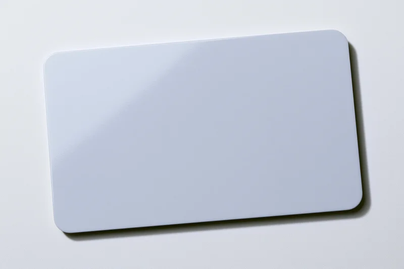 Blank white plastic card lying flat on white surface center