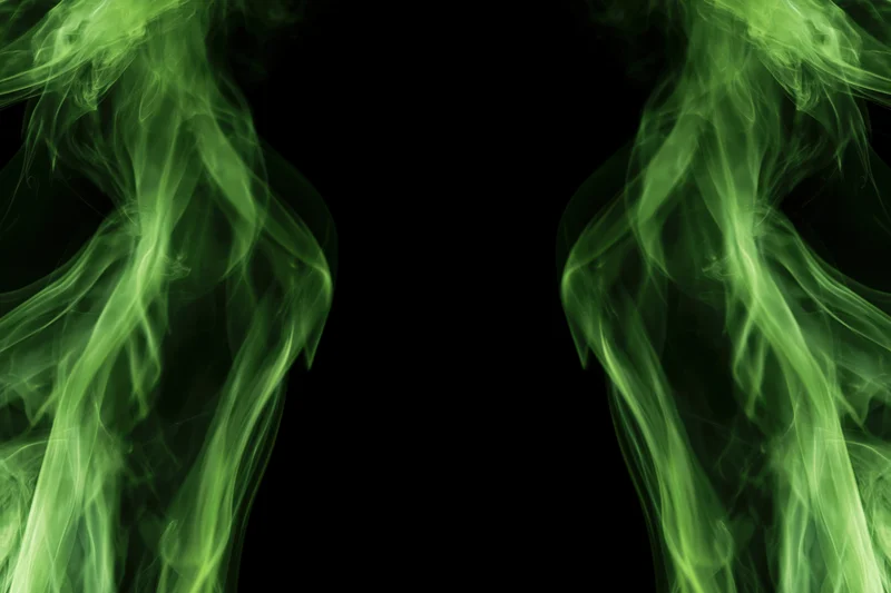 Neon green smoke wisps rising from both lower corners against black background