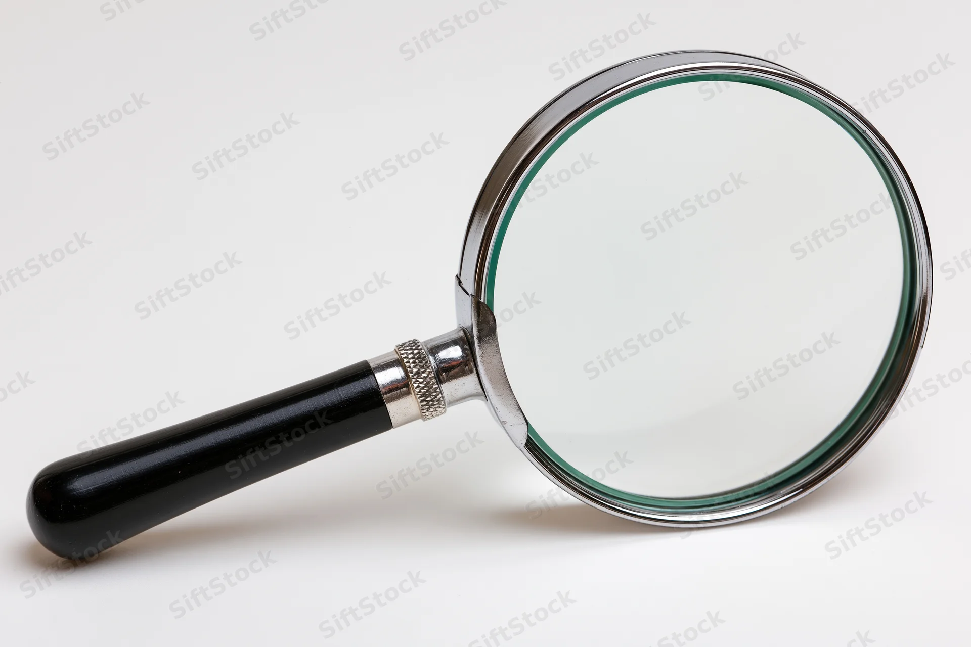 Classic magnifying glass with black handle and silver chrome frame on white background