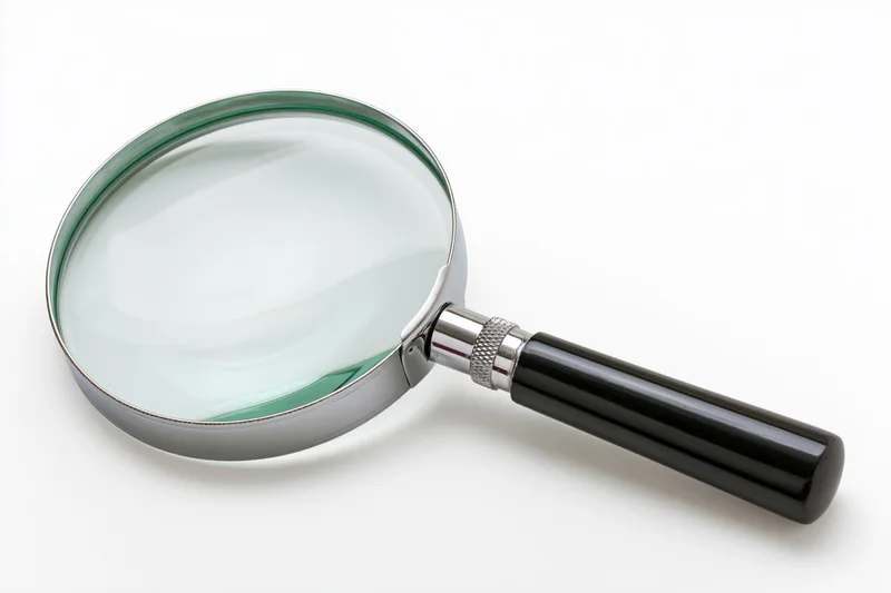 Classic magnifying glass with black handle and silver chrome frame on white background