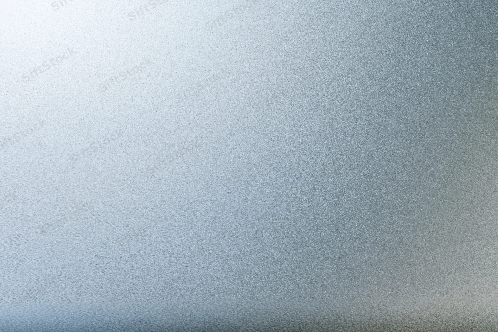 Close-up flat lay of a brushed aluminum surface with subtle texture and gradient lighting