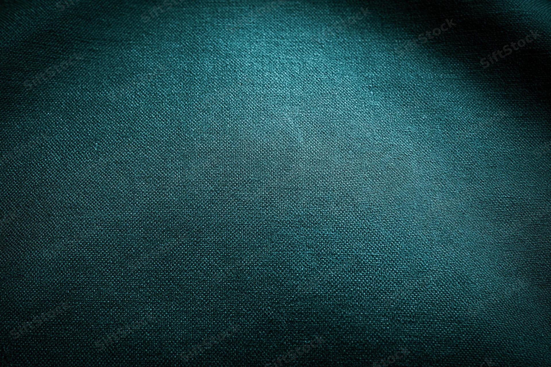 Close-up flat lay of dark forest green fabric surface filling frame