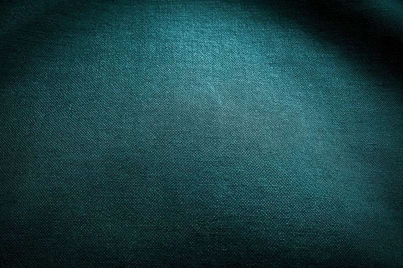 Close-up flat lay of dark forest green fabric surface filling frame