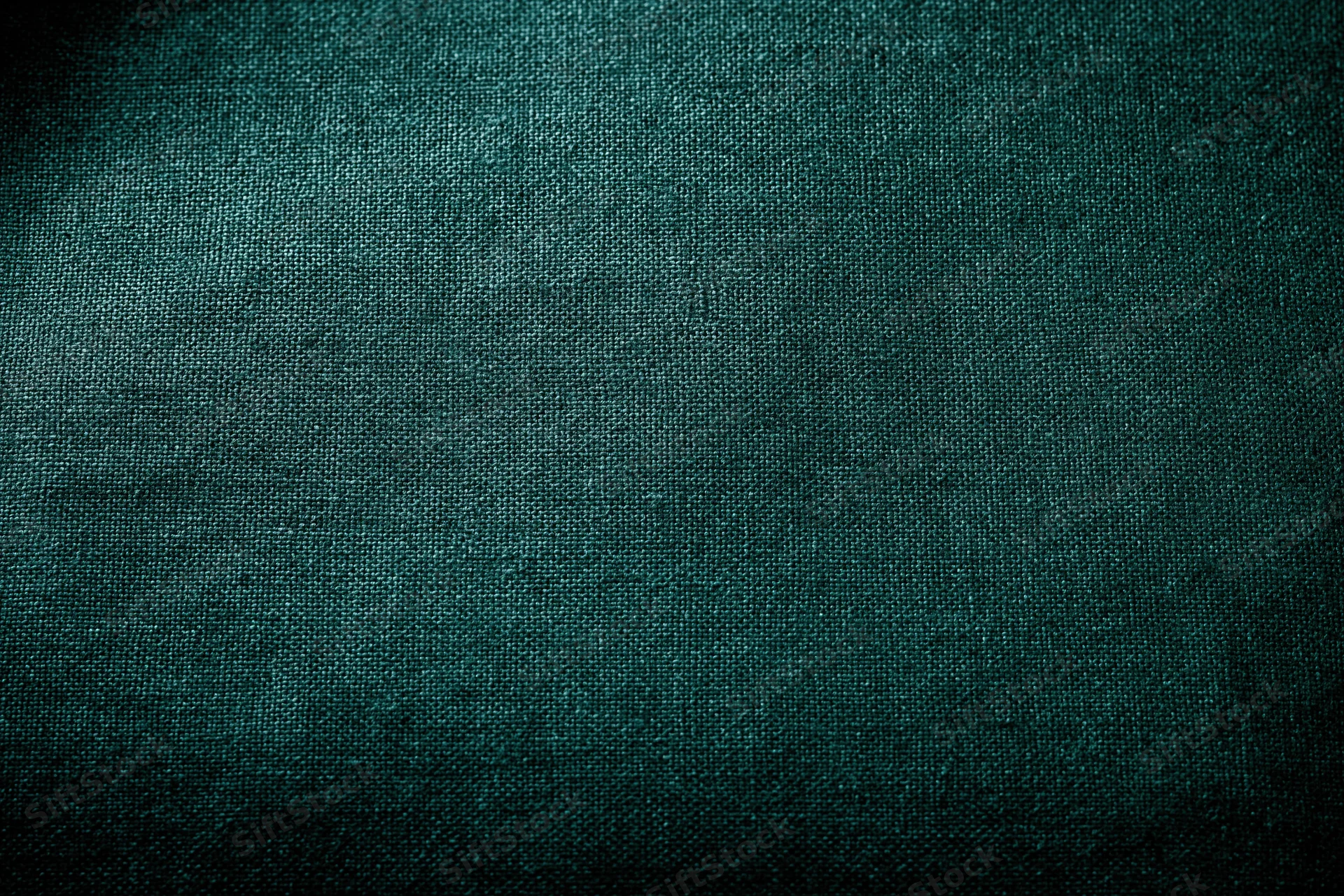 Close-up flat lay of dark forest green fabric surface filling frame