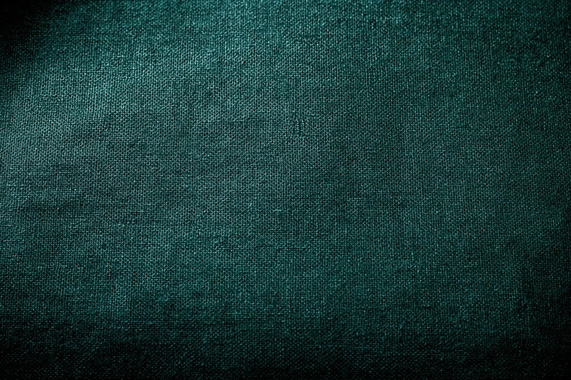 Close-up flat lay of dark forest green fabric surface filling frame