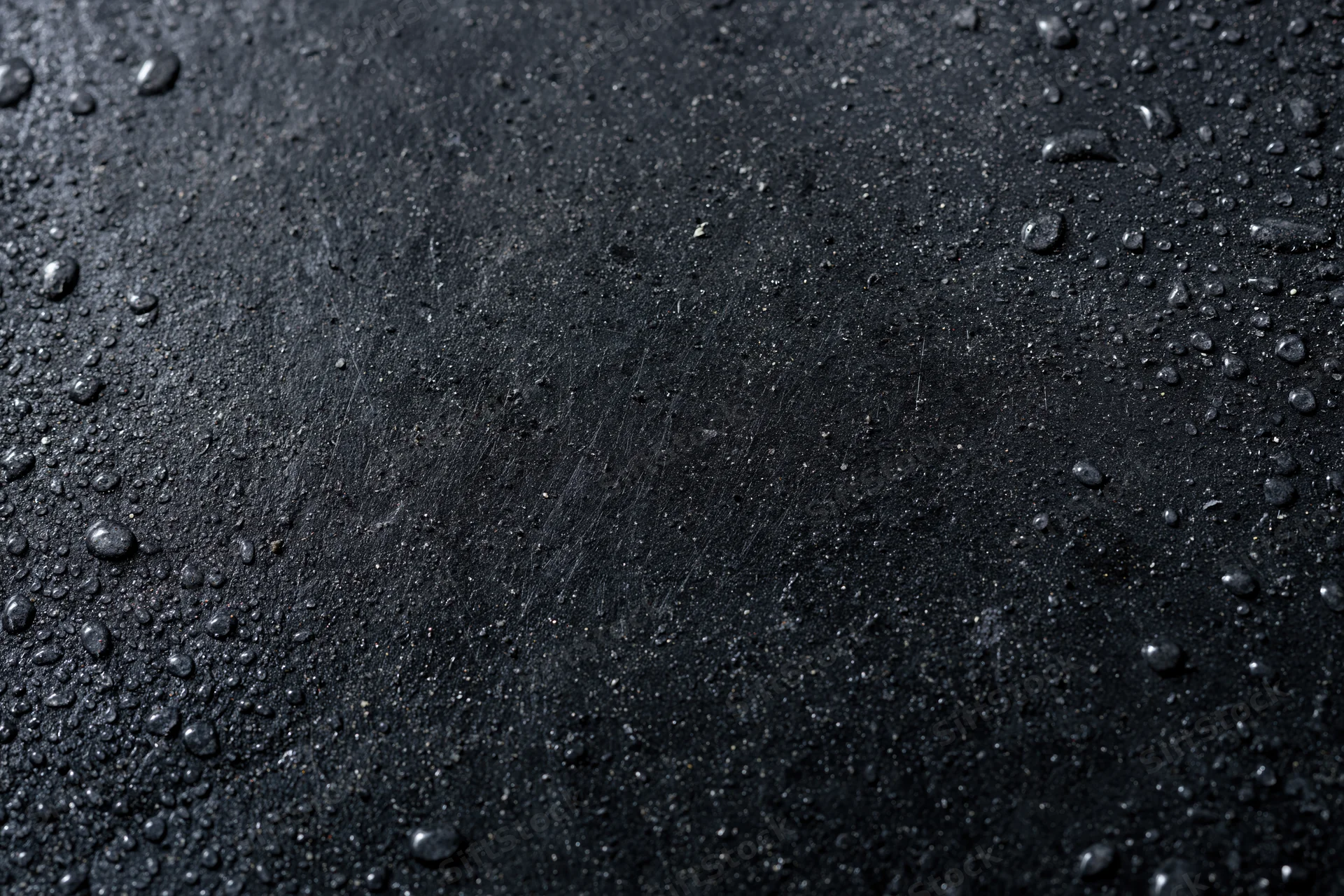 Wet dark concrete surface with water droplets in flat lay arrangement