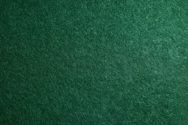 Close-up flat lay of deep forest green felt surface