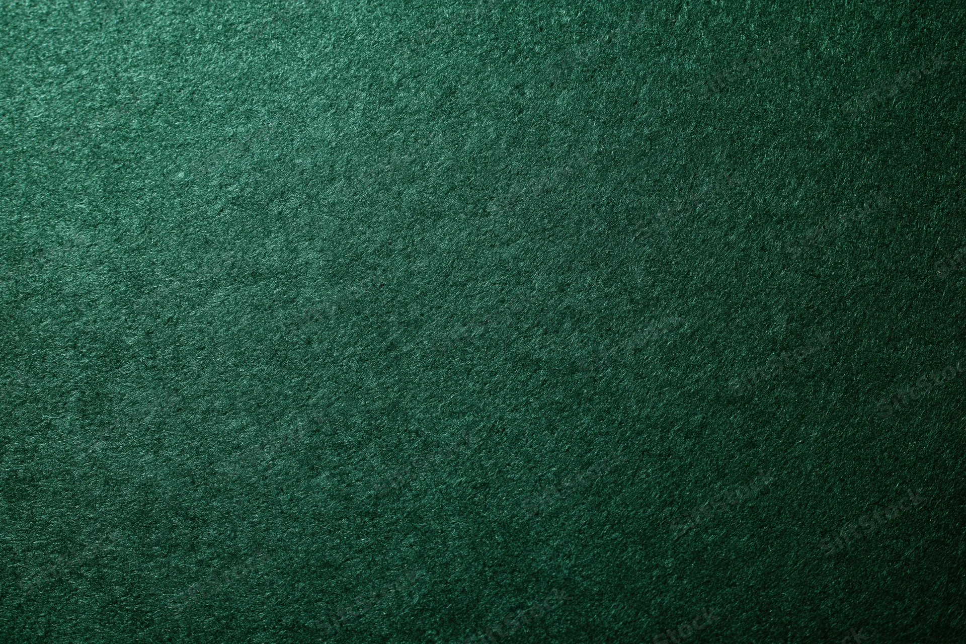 Close-up flat lay of deep forest green felt surface with visible texture and grain