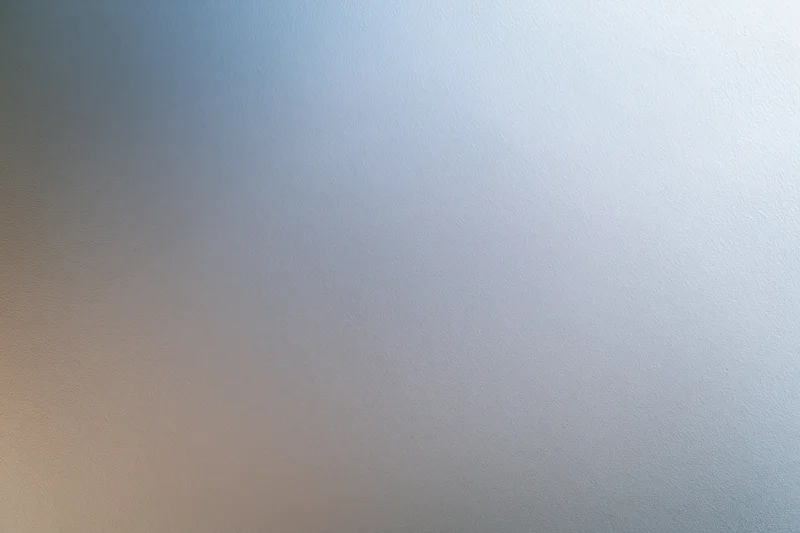 Close-up of a frosted glass or brushed metal surface with a smooth gradient texture