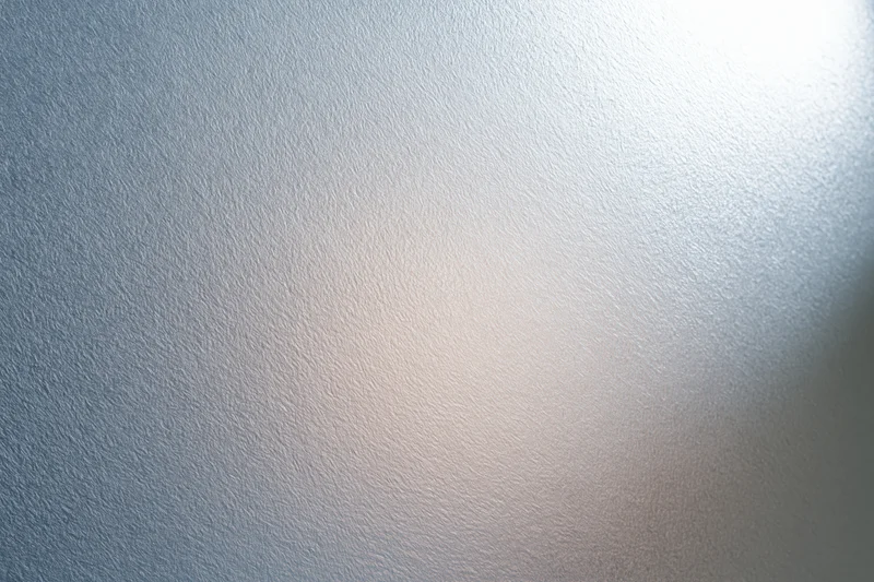 Close-up of frosted glass surface with soft light gradient and subtle texture