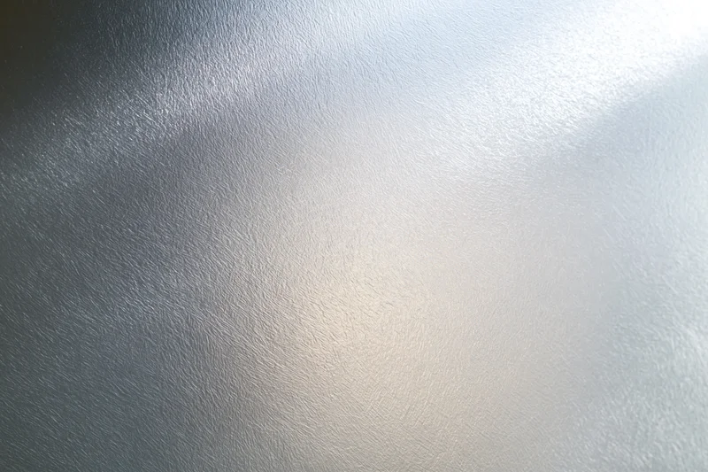 Close-up of frosted glass surface with soft light gradient and subtle texture