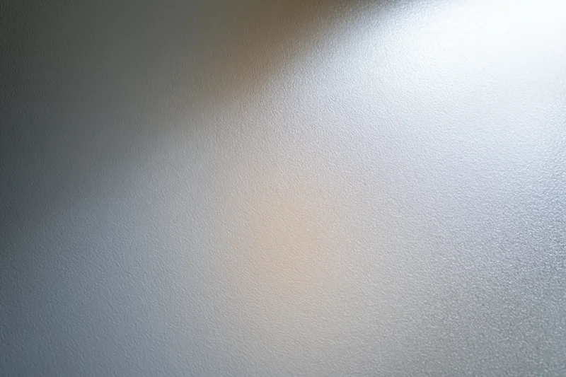 Close-up of frosted glass surface with soft light gradient and subtle texture