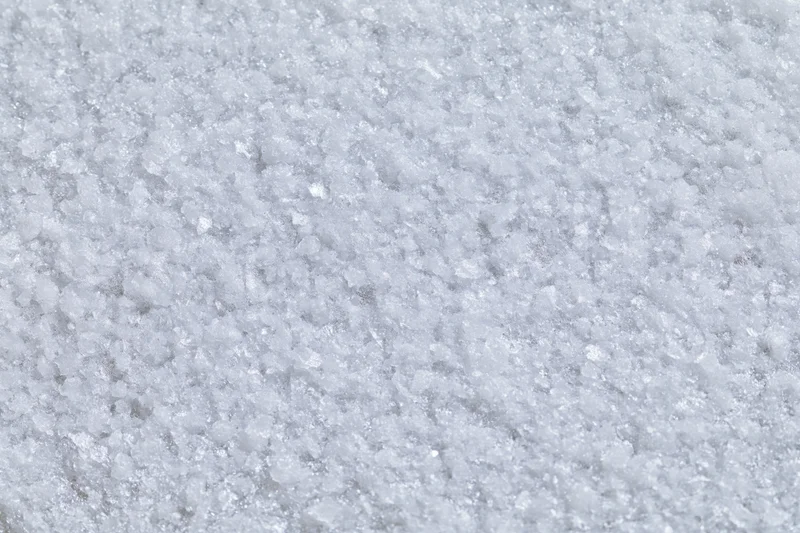 Close-up flat lay of a frosted white metal surface with textured grain pattern