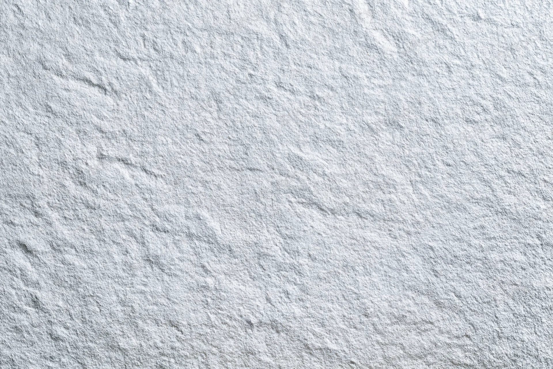 Close-up of a white frosted metal surface with textured grain pattern