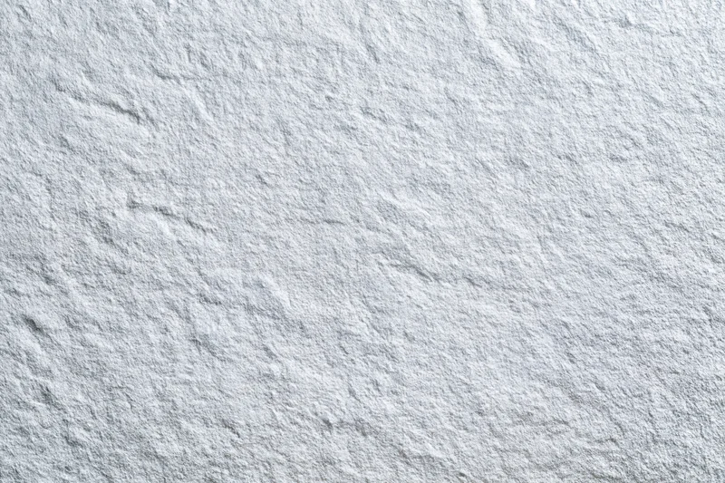 Close-up of a white frosted metal surface with textured grain pattern