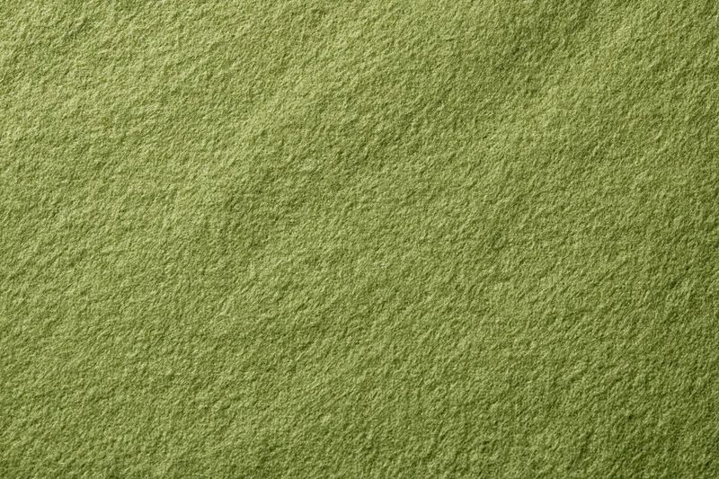 Close-up flat lay of muted olive green fabric surface filling frame