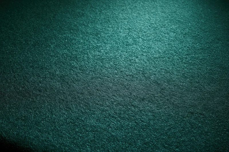 Close-up flat lay of green felt poker table surface