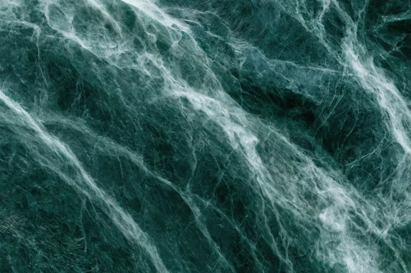 Polished dark emerald green marble slab with natural veining and glossy surface