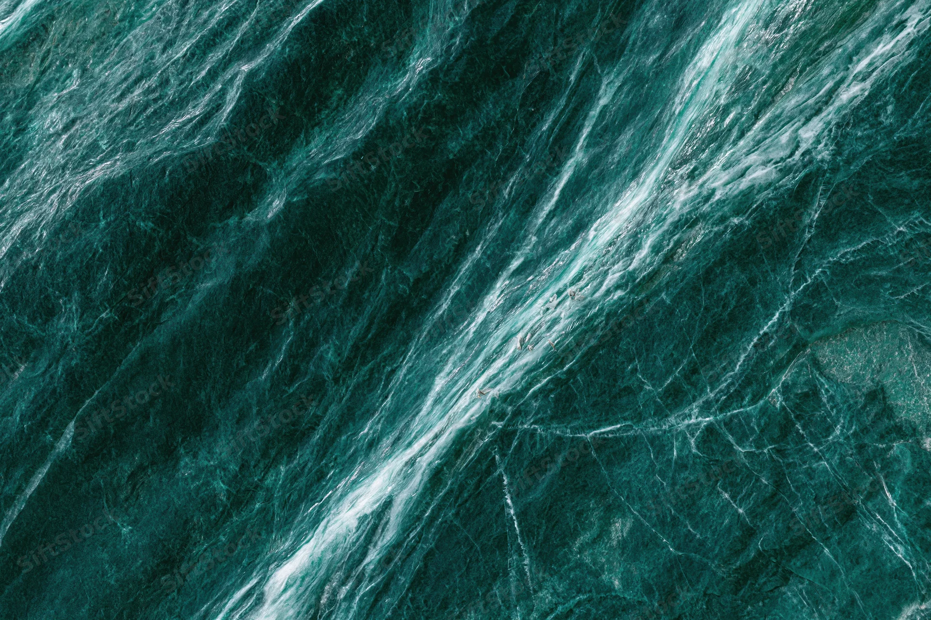 Polished dark emerald green marble slab with natural veining and glossy surface
