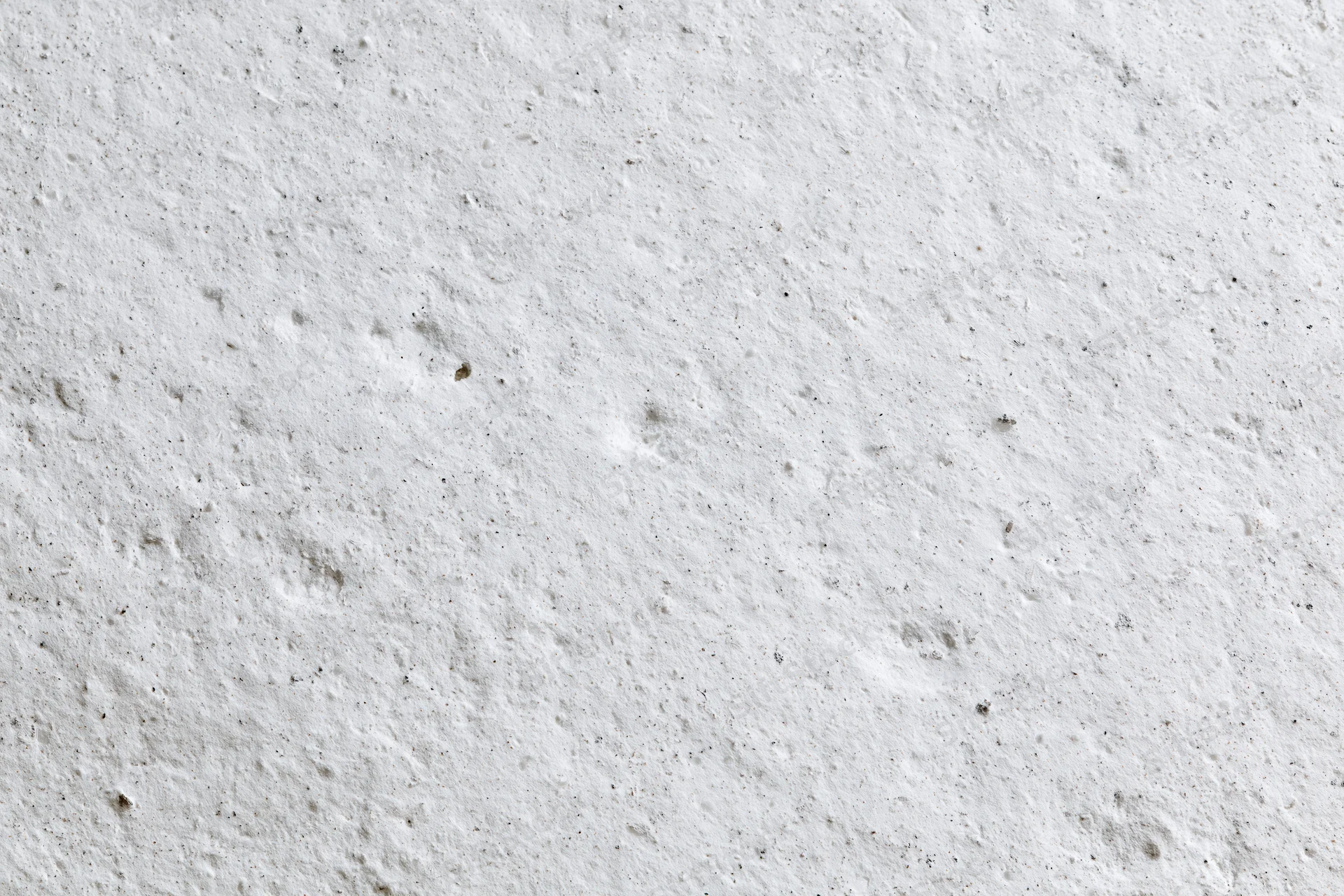 Close-up of rough white concrete wall surface with visible texture and imperfections