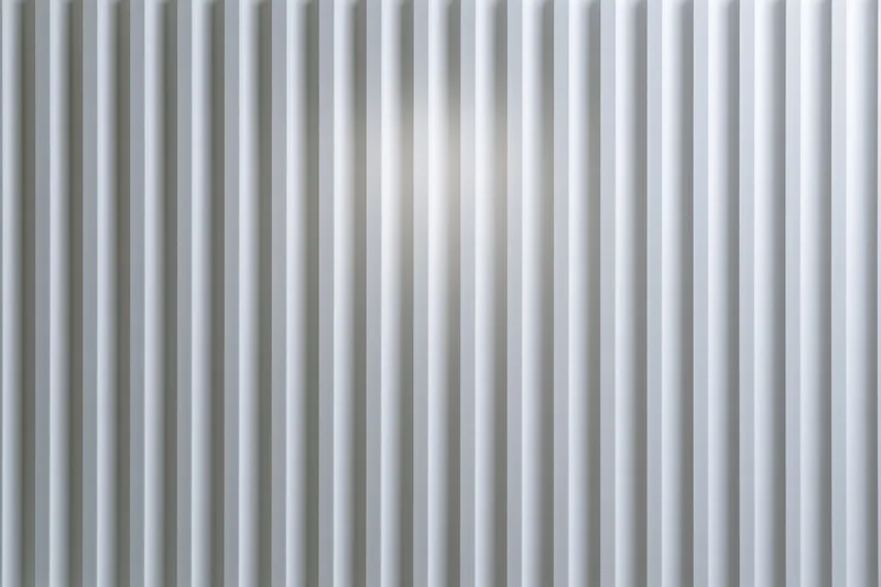 White ribbed panel surface filling the frame with vertical grooves and subtle light reflection