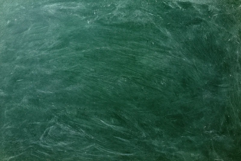 Worn green chalkboard surface with smudged chalk residue filling the frame in a flat lay view