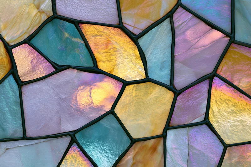 Close-up flat lay of an iridescent stained glass mosaic panel with geometric shapes and vibrant colors