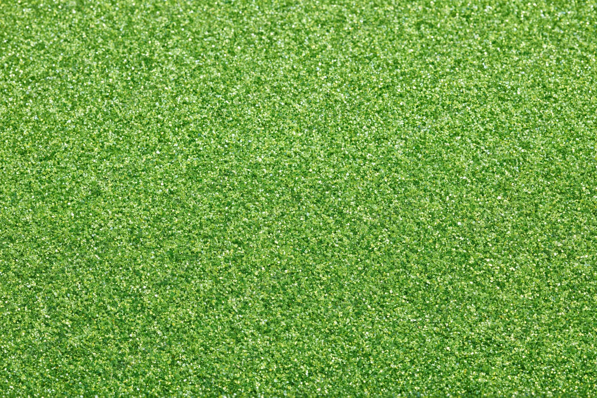 Bright green glitter texture filling the frame in a flat lay arrangement