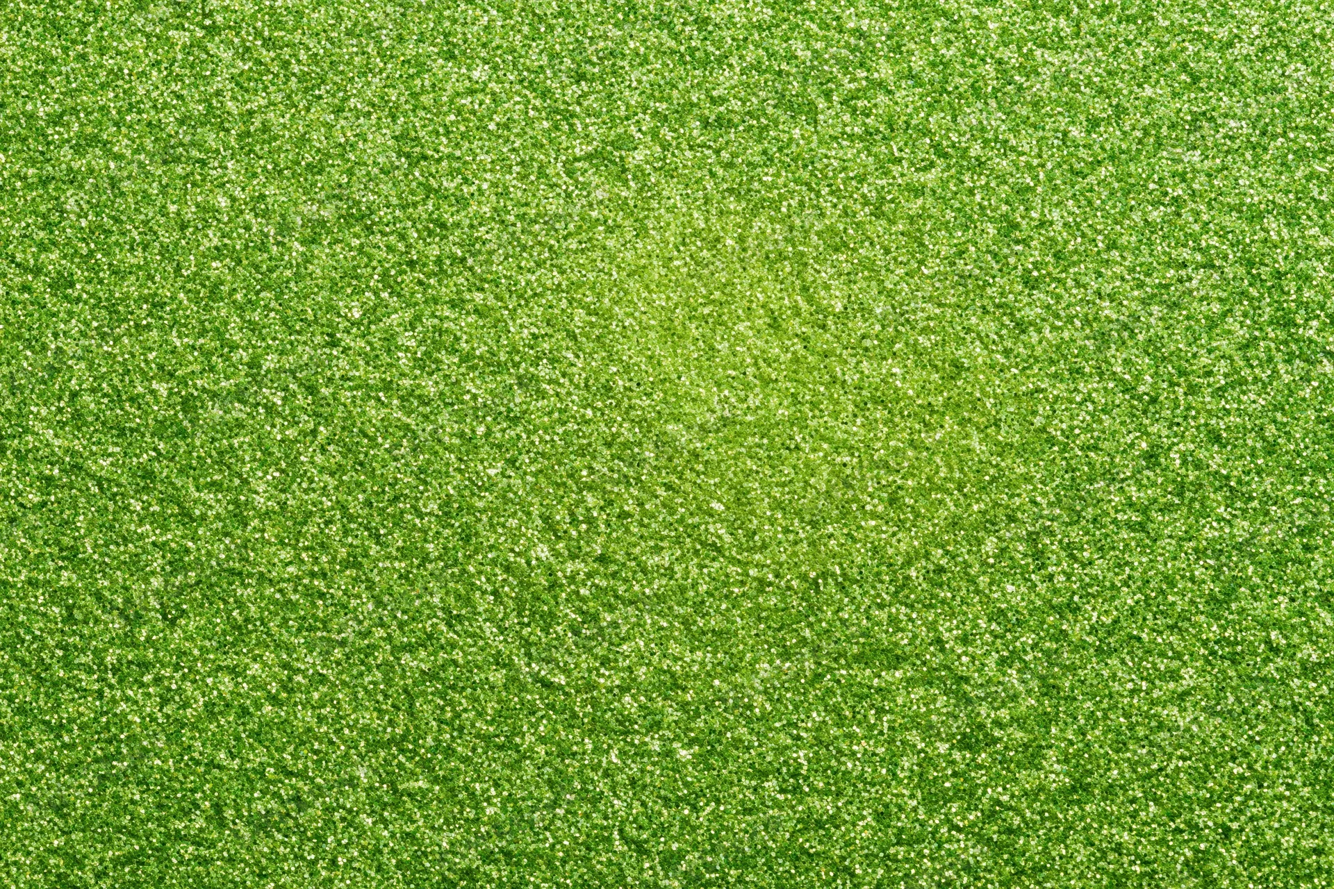 Bright green glitter texture filling the frame in a flat lay close-up view
