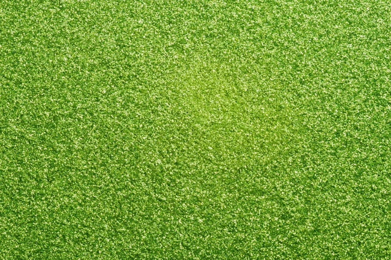 Bright green glitter texture filling the frame in a flat lay close-up view