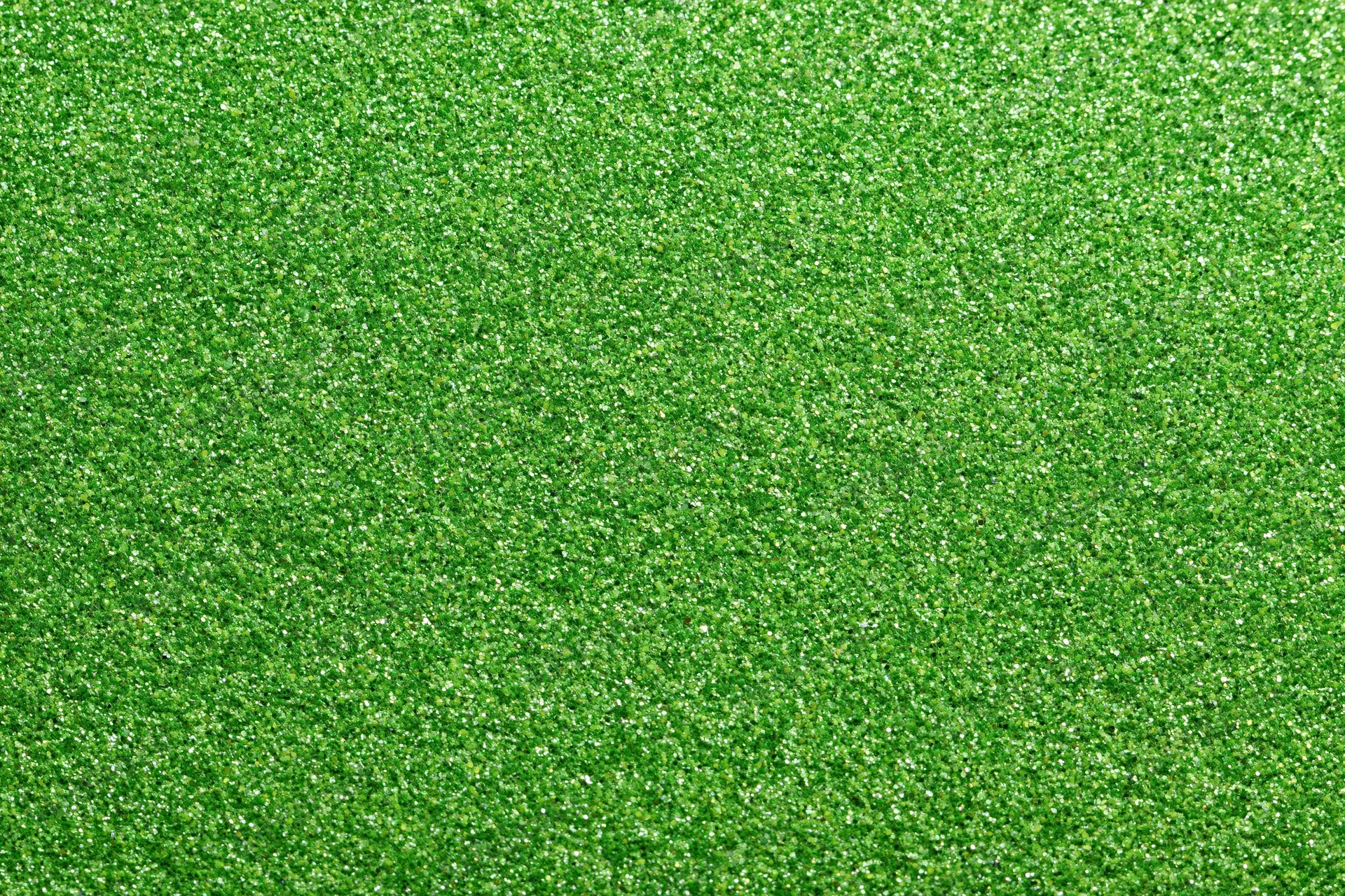 Bright green glitter texture filling the frame in a flat lay close-up view