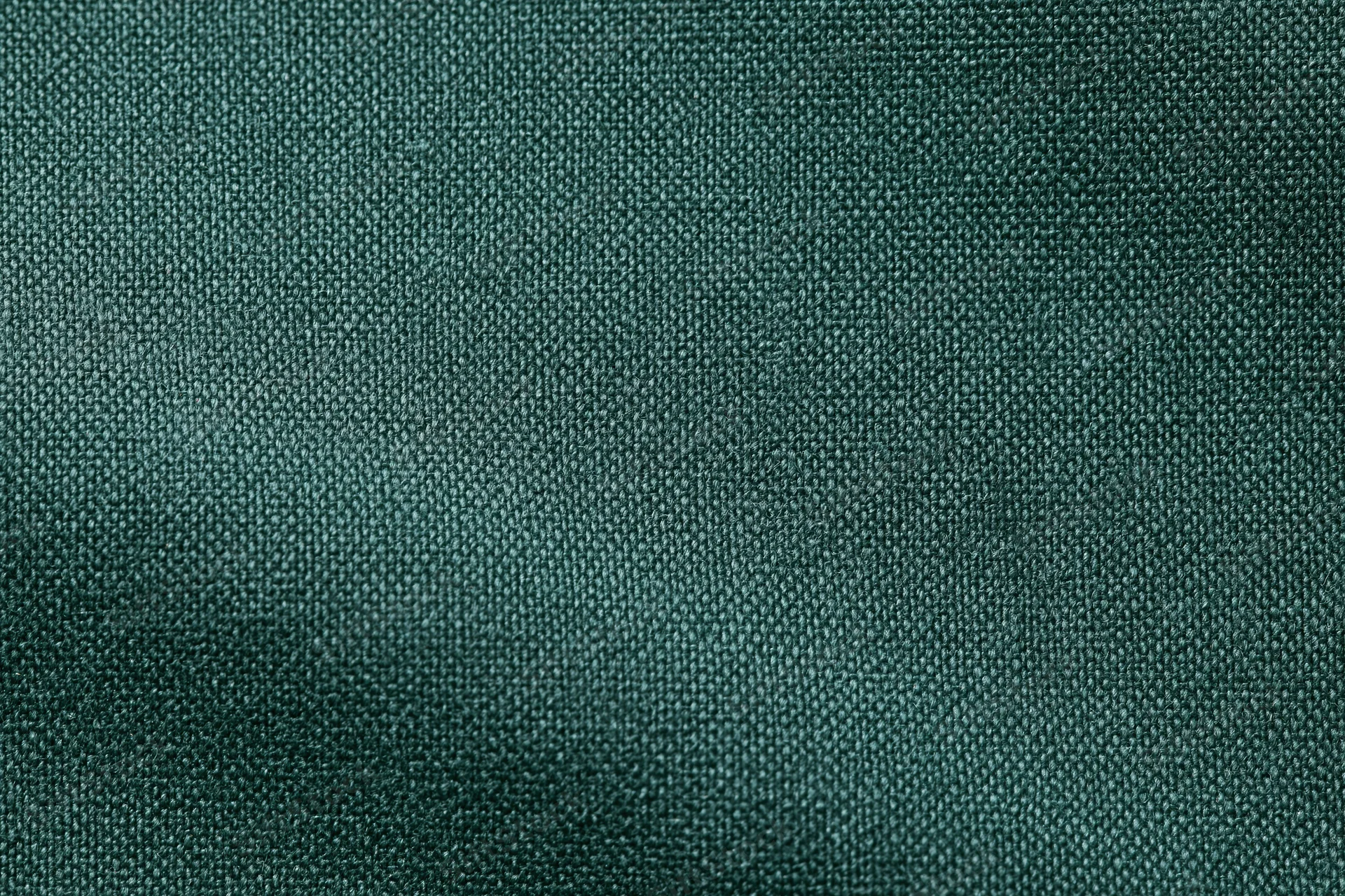 Dark forest green woven fabric textile in flat lay closeup filling frame