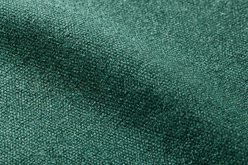 Dark forest green fabric textile filling in flat lay closeup
