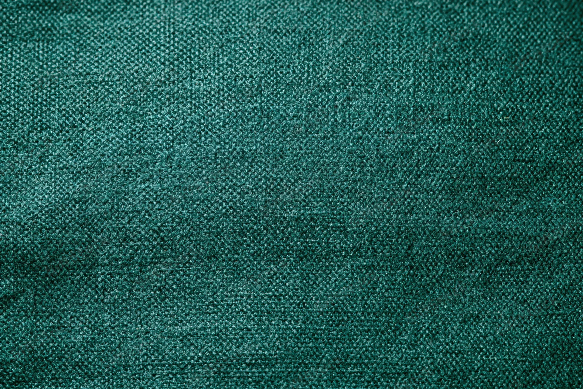 Dark forest green woven fabric filling the frame in a flat lay close-up