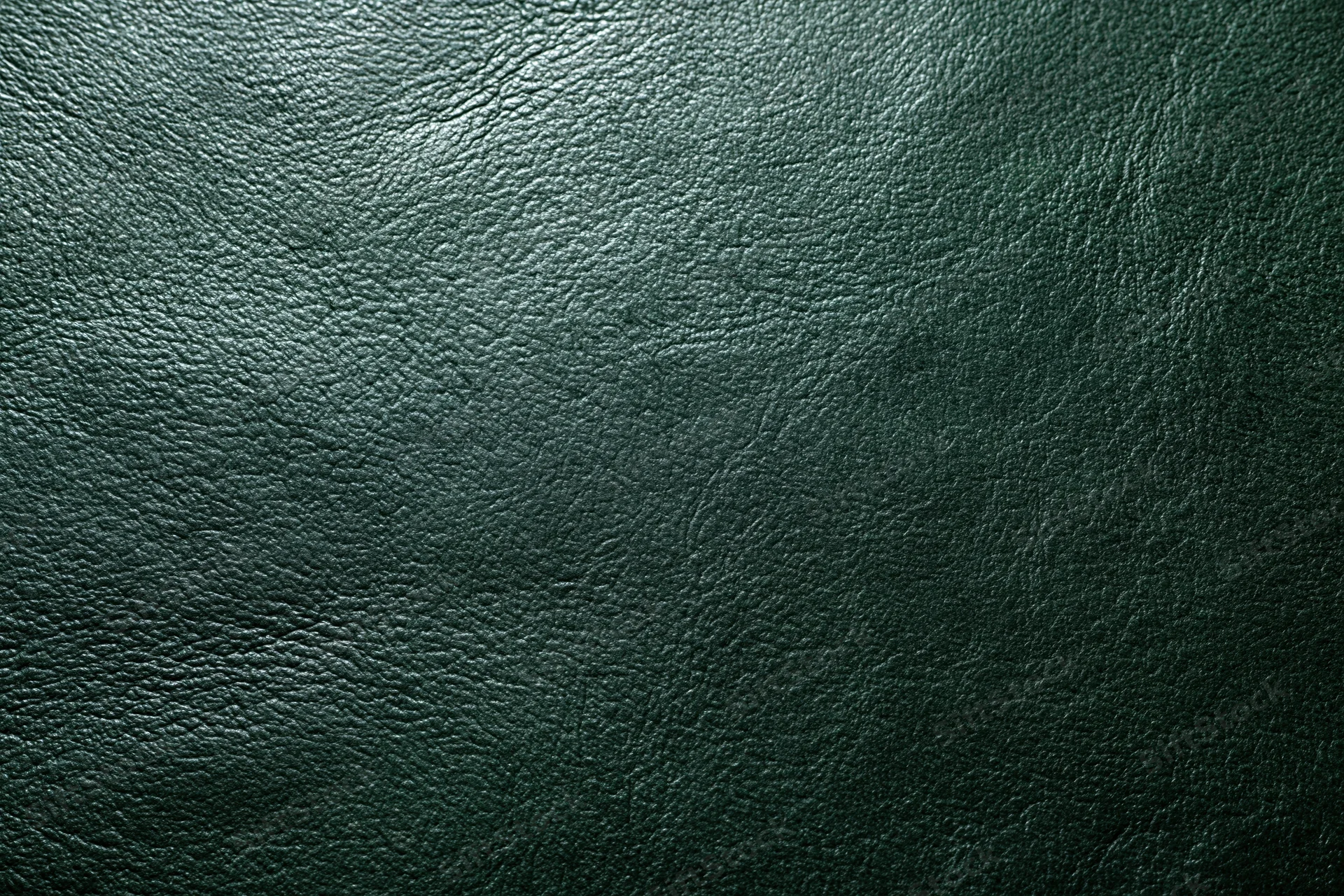 Dark forest green leather surface in flat lay closeup filling frame