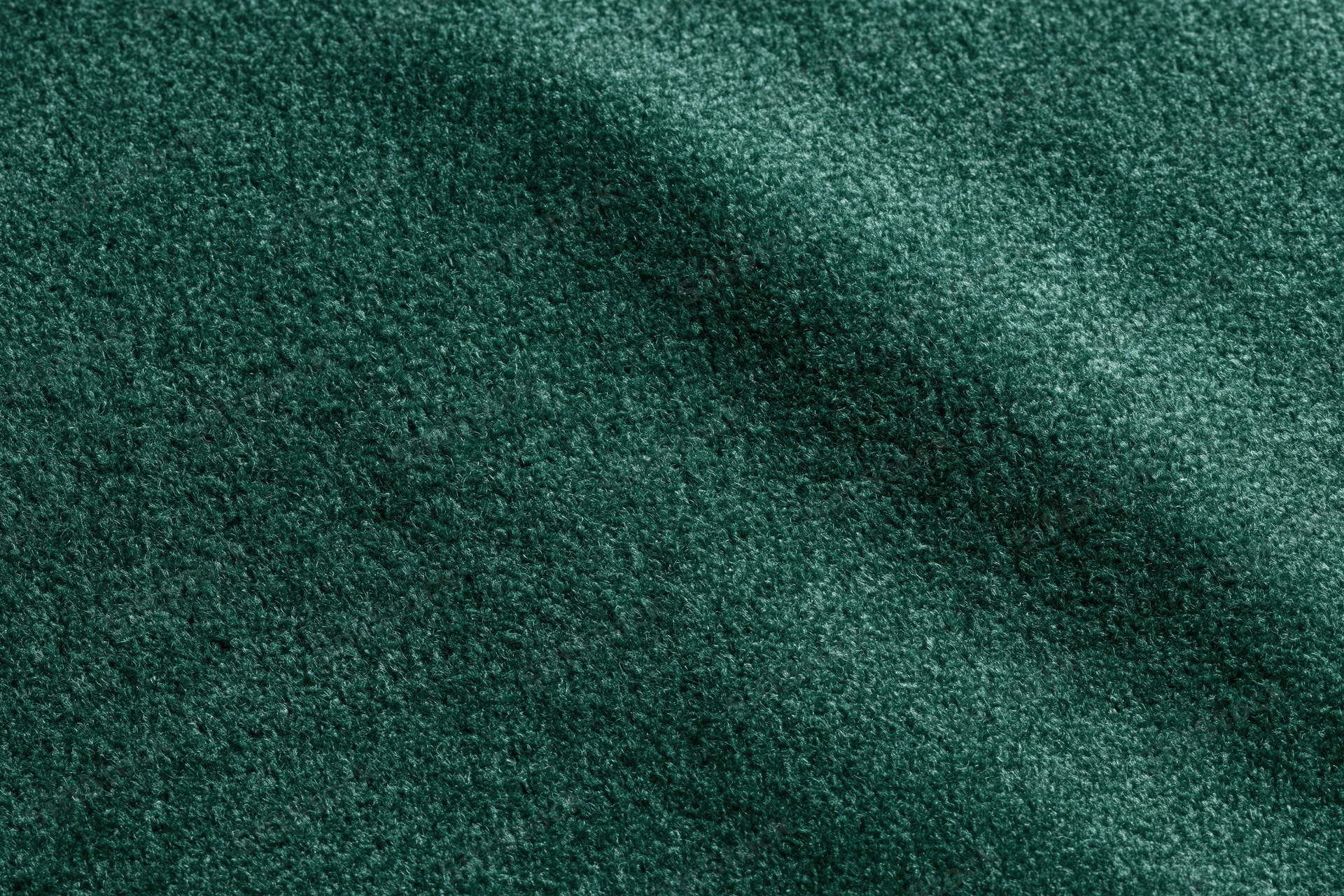 Dark green velvet fabric in close-up flat lay filling the frame