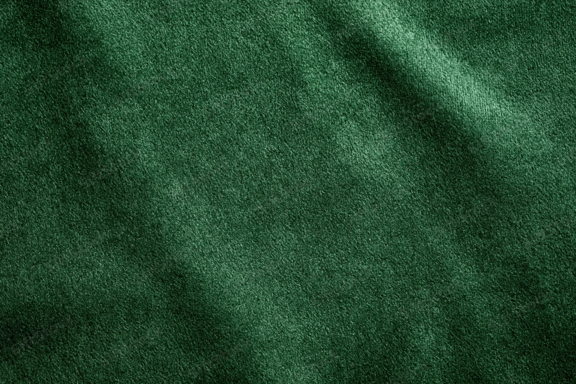 Dark green velvet fabric in close-up flat lay filling the frame