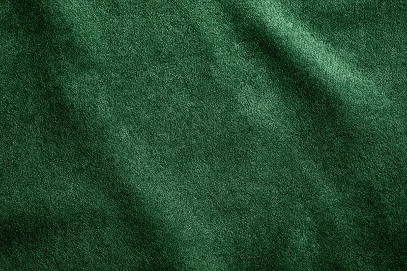 Dark green velvet fabric in close-up flat lay filling the frame