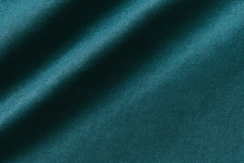 Close-up flat lay of deep teal fabric filling the frame
