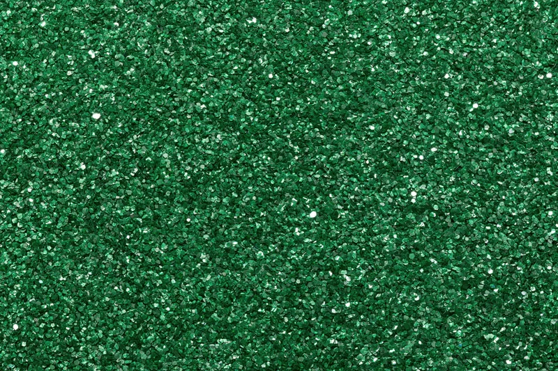 Dense green glitter filling the frame in a flat lay close-up view