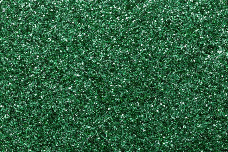 Dense green glitter filling the frame in a flat lay close-up view